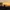 Group of people on a mountain peak celebrating at sunset with arms raised.