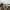 Blurry bicycle in front of a sandy beach and calm sea on a cloudy day.