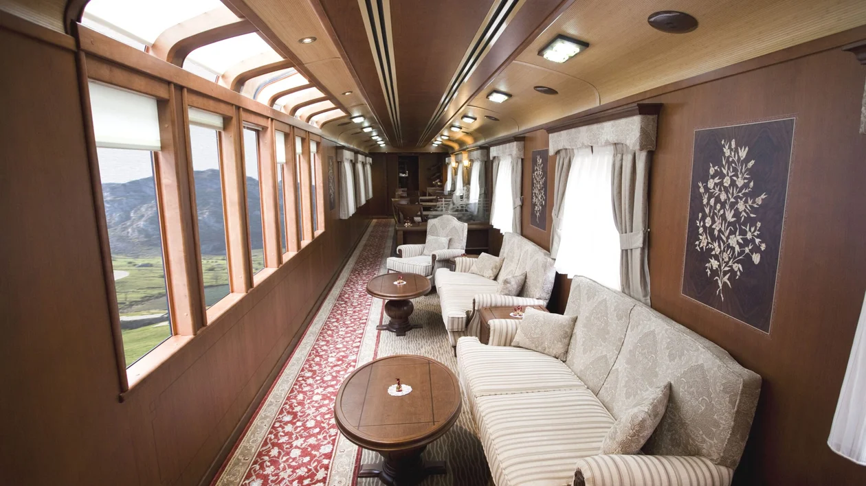 Interior of a train with comfortable sofas and a large panoramic window.