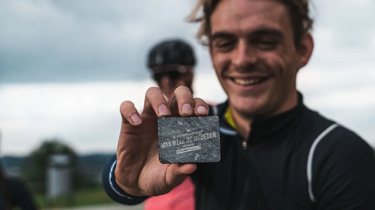 Group of cyclists riding on a cobblestone path surrounded by greenery.
