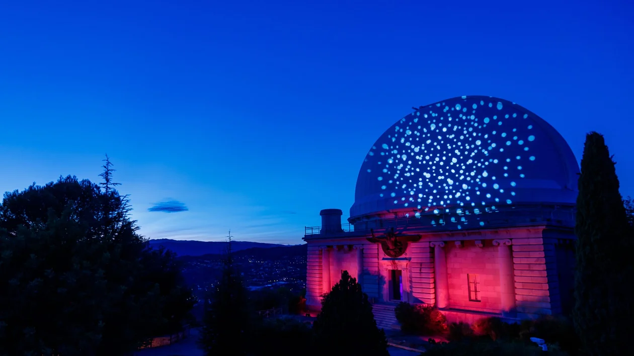 Nice Observatory illuminated with star-shaped projections against a deep blue winter sky, highlighting its architectural elegance.