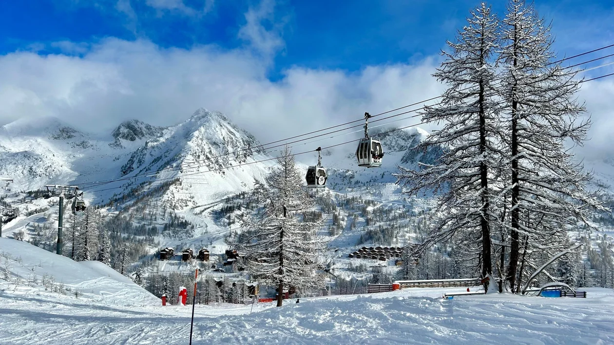 Snow-covered slopes and ski lifts at Isola 2000 in the French Alps, with pristine white mountains under a clear blue sky.