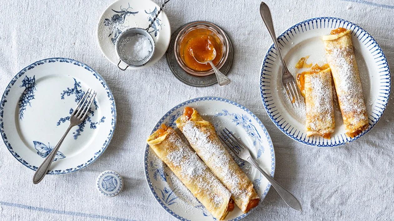 Austrian Marillen Palatschinken, sweet apricot pancakes dusted with powdered sugar, served as a traditional dessert.