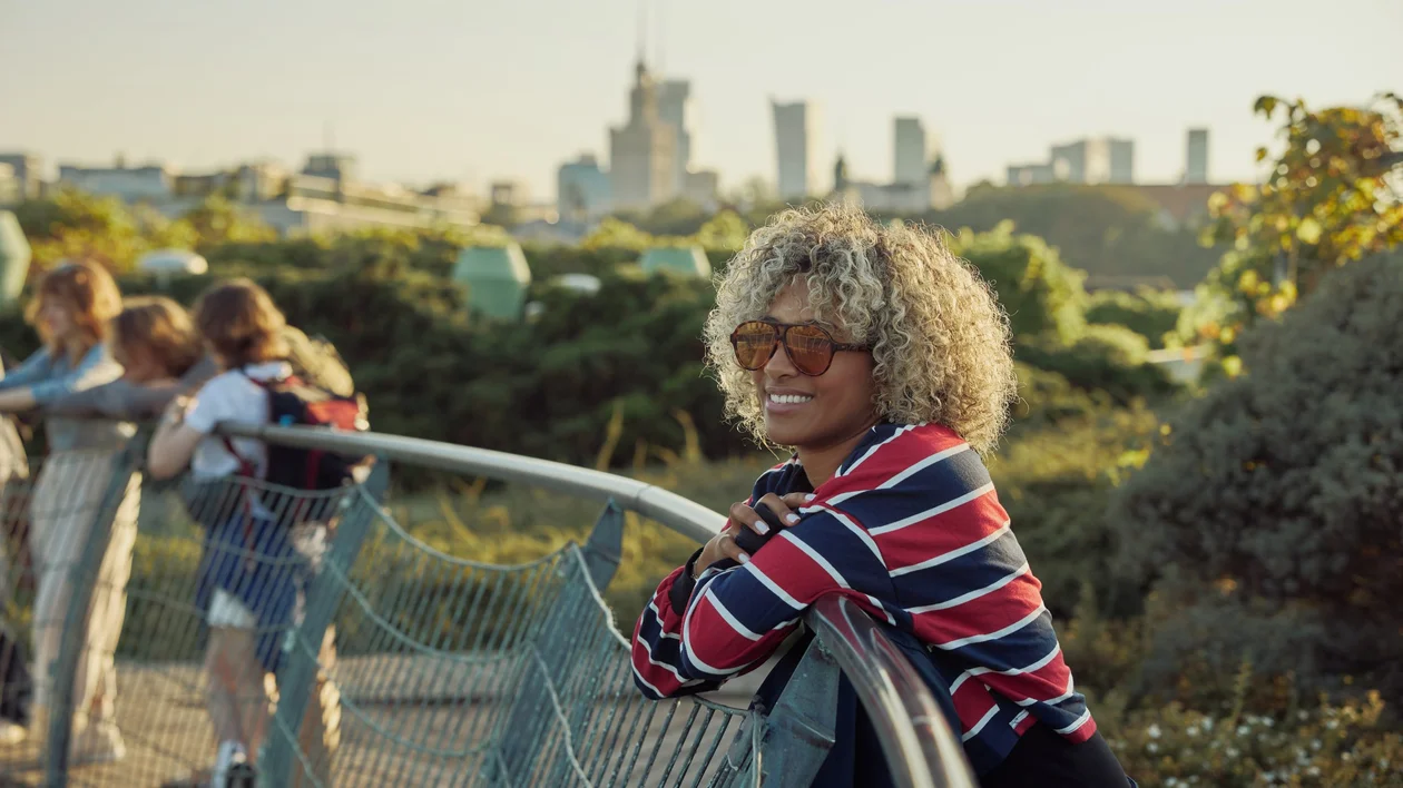 Woman enjoying the rooftop gardens in Warsaw with the modern city skyline in the background.