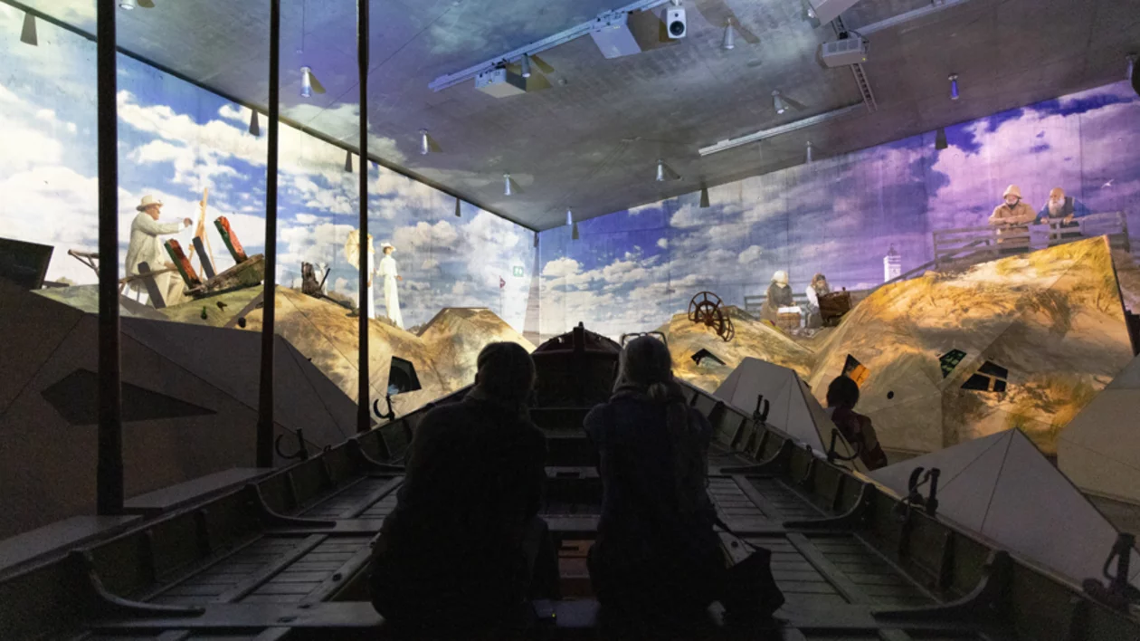 Immersive exhibit at TIRPITZ Museum, Denmark, featuring visitors viewing a projected World War II-era bunker scene.