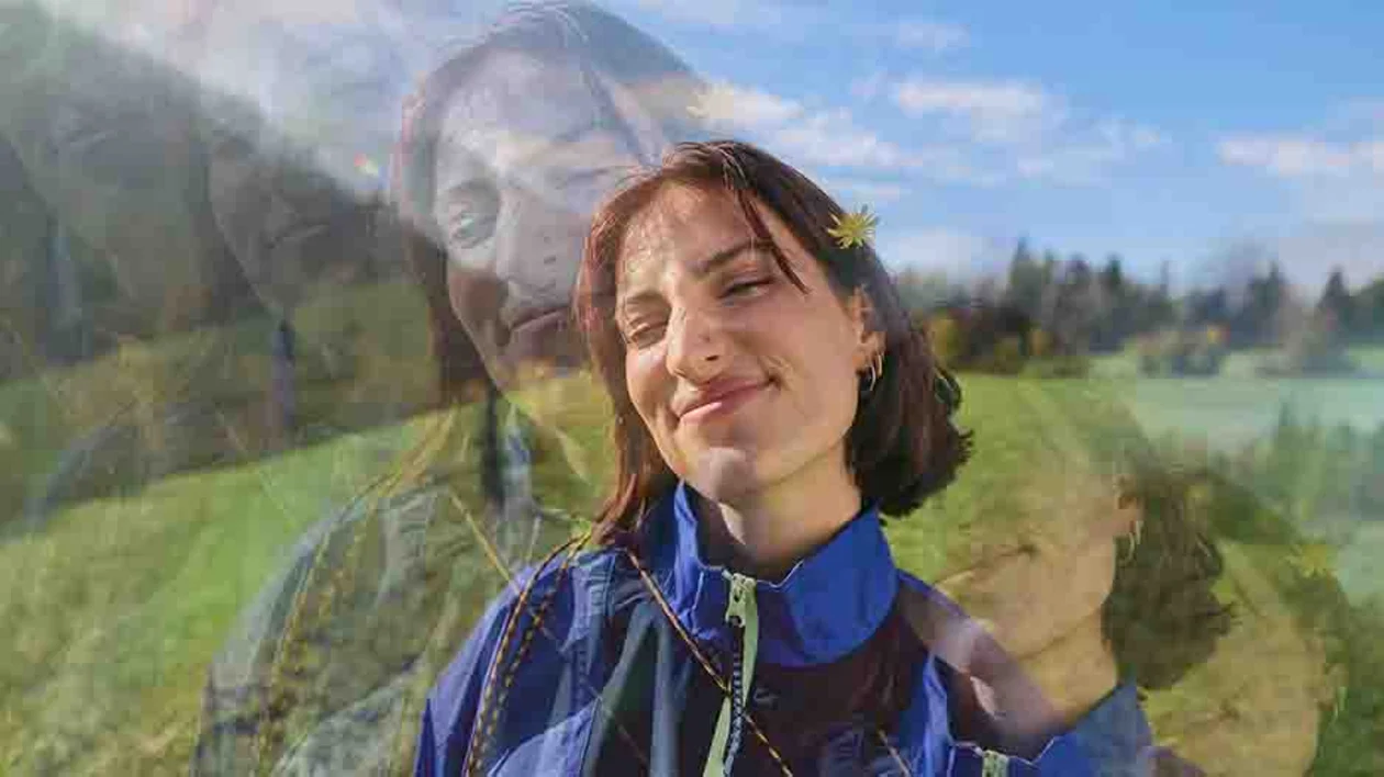 Double exposure portrait of a happy traveler smiling in a sunny green meadow