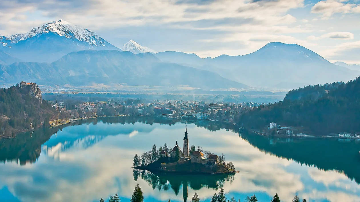 Island church on Lake Bled with mountains behind
