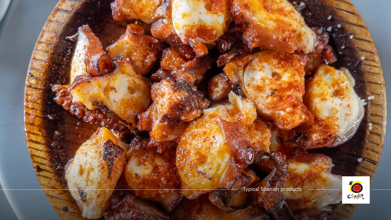 Chopped octopus with paprika and seasoning on a wooden plate.