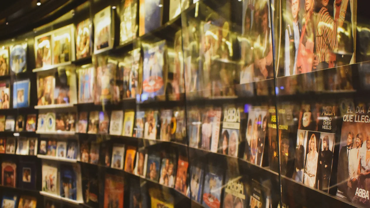 Curved wall display of colorful framed photographs in a warmly lit room.