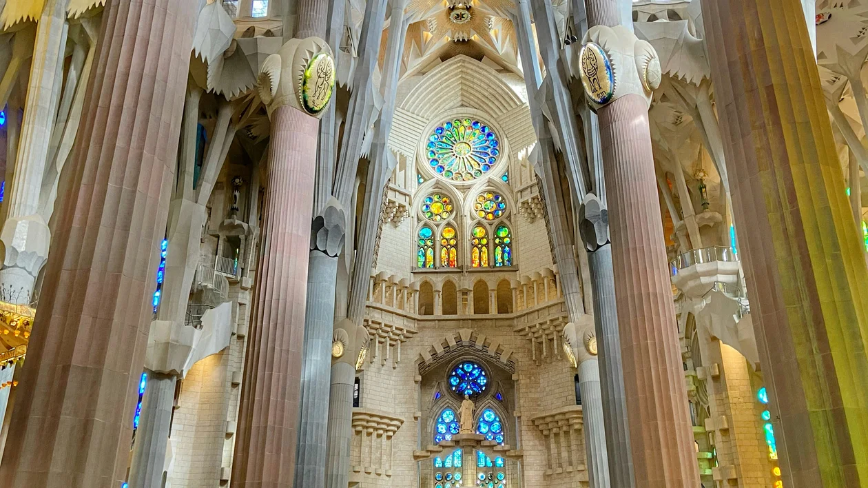 Tall stone columns and colorful stained glass windows inside a grand cathedral.