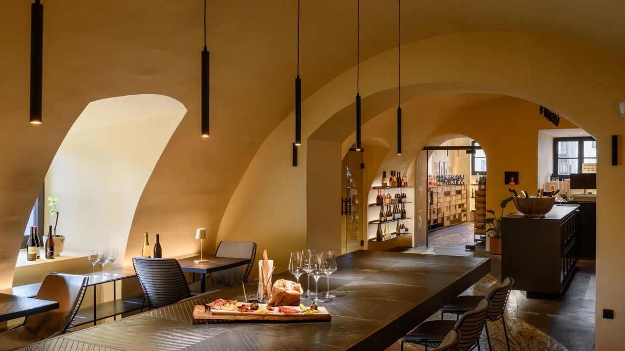 Cozy restaurant with arched ceilings, modern lighting, and a set dining table.