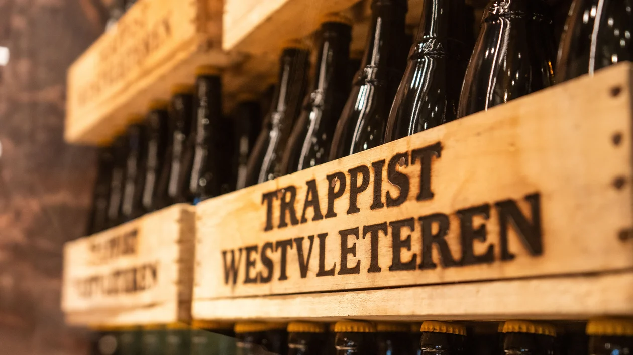 Wooden crates of Trappist Westvleteren beer bottles stacked on shelves.