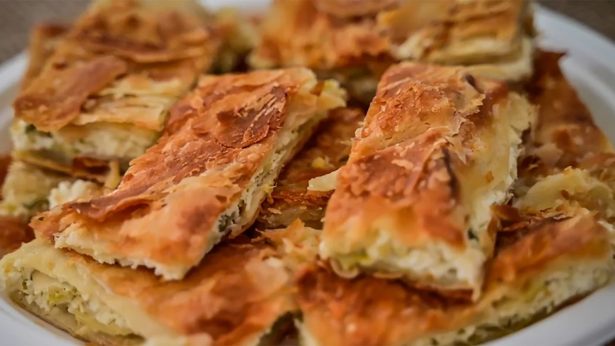 Flaky pastry squares stacked on a white plate