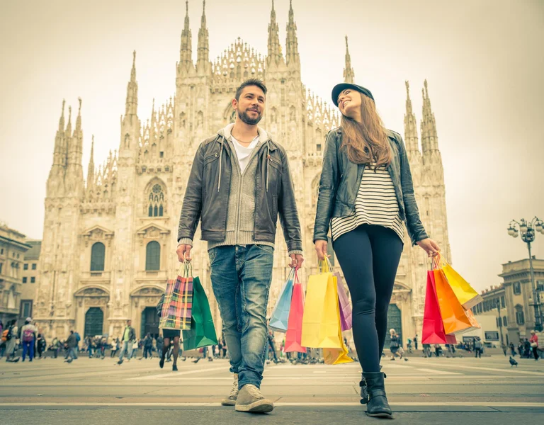 Attractive man and woman holding shopping bags and having fun in Milan
