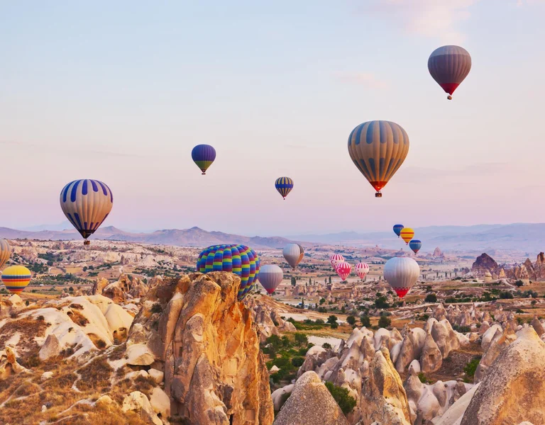 Hot air balloon flying over rock landscape at Cappadocia
