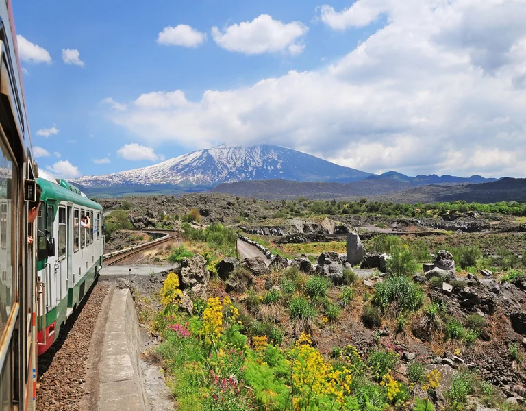 Train in Sicily with Etna mountain behind. Scenic view.