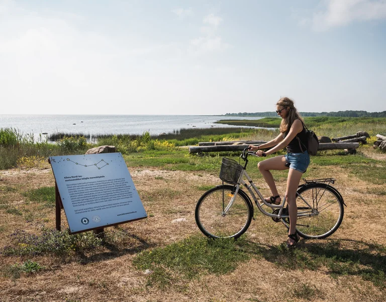 a girl on a bike is studying the reading some information about stars