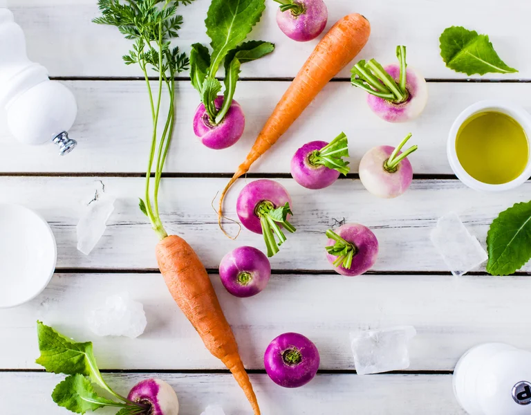Featuring a vibrant selection of fresh vegetables, this image celebrates the simplicity and seasonality of Latvian produce. The natural colours and textures of the carrots and turnips are a testament to the importance of fresh, locally grown ingredients in the region's cuisine.