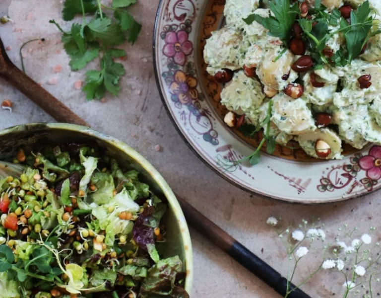 A salad plait and a potato salad displayed on a table.