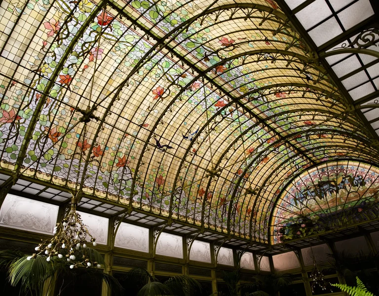 An Art Nouveau glass celing decorated with nature details, such as flowers and leaves.