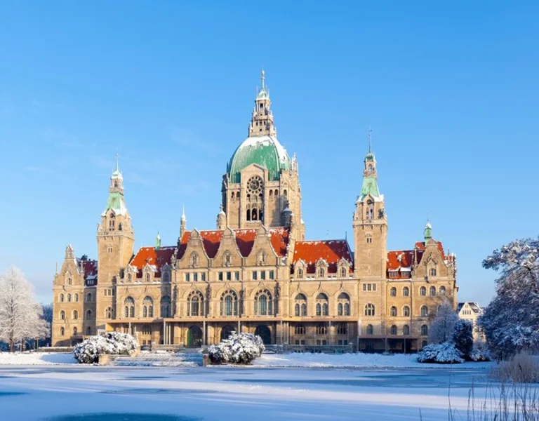 Panoramic view of a snowy landscape featuring a grand historic building with a central dome.