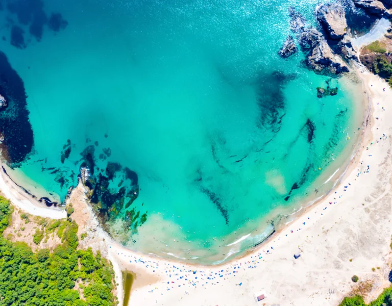 Aerial view of a secluded crescent-shaped turquoise beach.