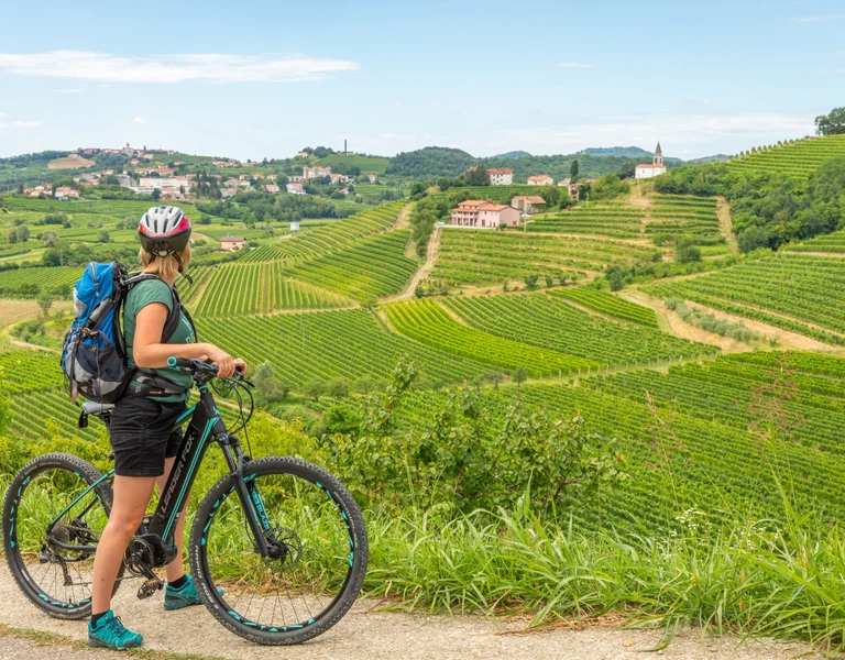 One woman cycling around the gorgeous and green landscapes.