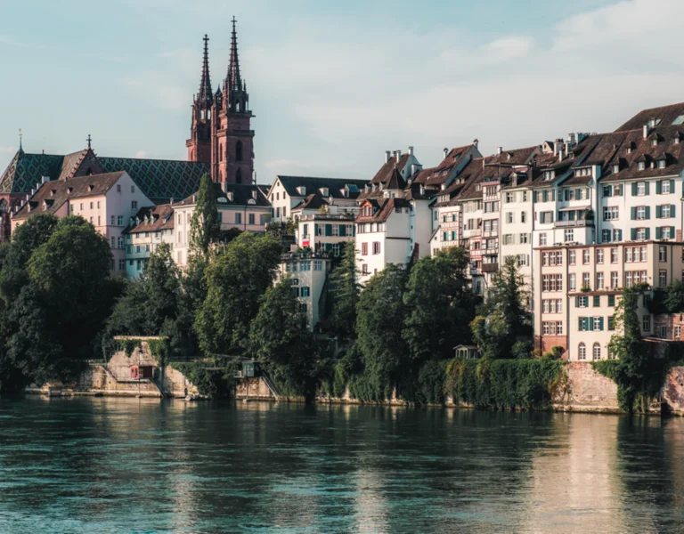 Panoramic view of Basel, Switzerland, showing the Rhine River, historic city center, and modern architecture.