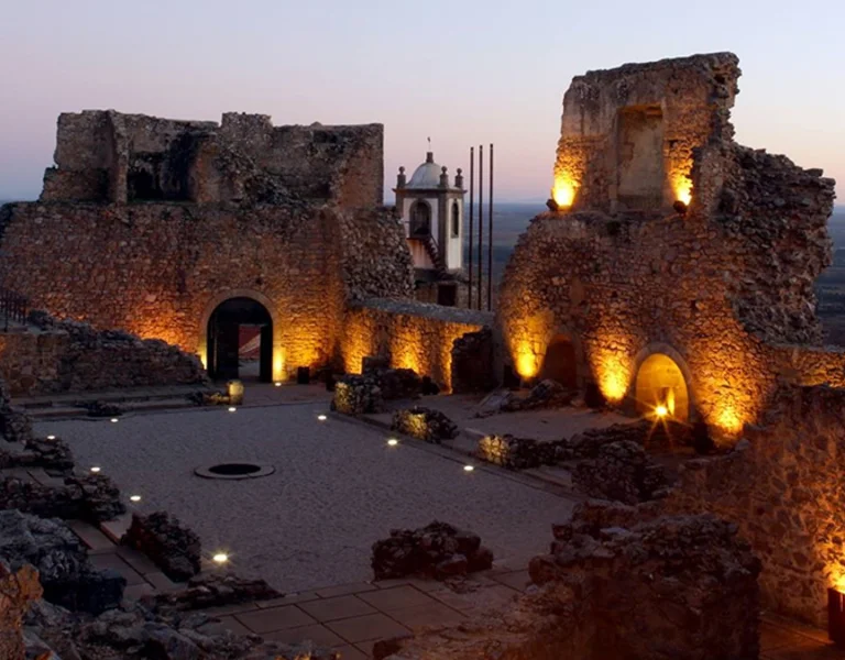 Illuminated ruins of Castelo Rodrigo fortress at dusk in Portugal