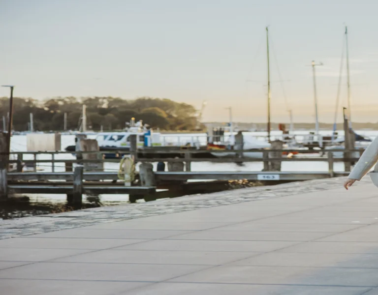 Couple walking along a waterfront promenade at sunset