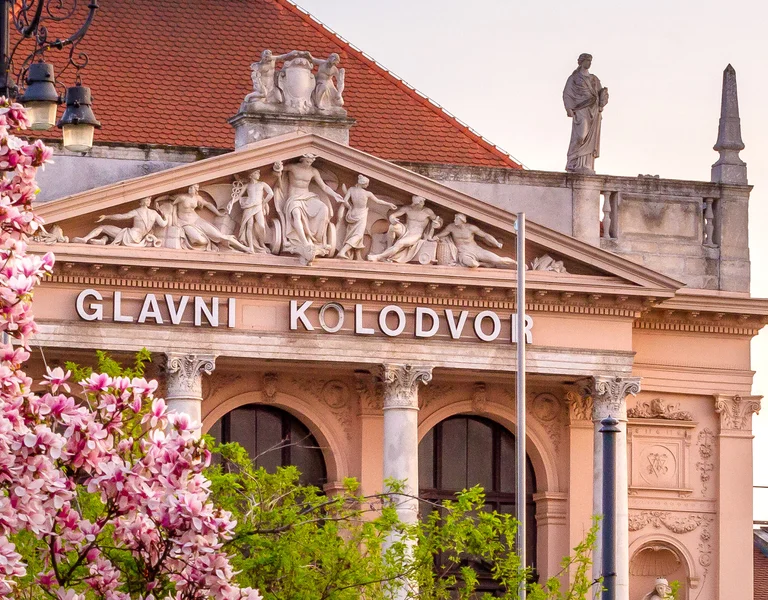 Classical building framed by blooming pink magnolia trees in spring.