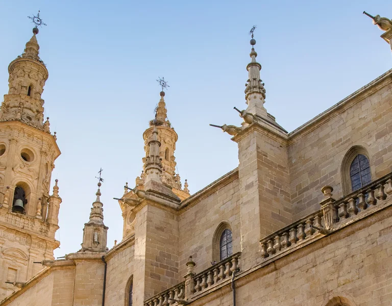 Historic stone cathedral towers against a clear blue sky.
