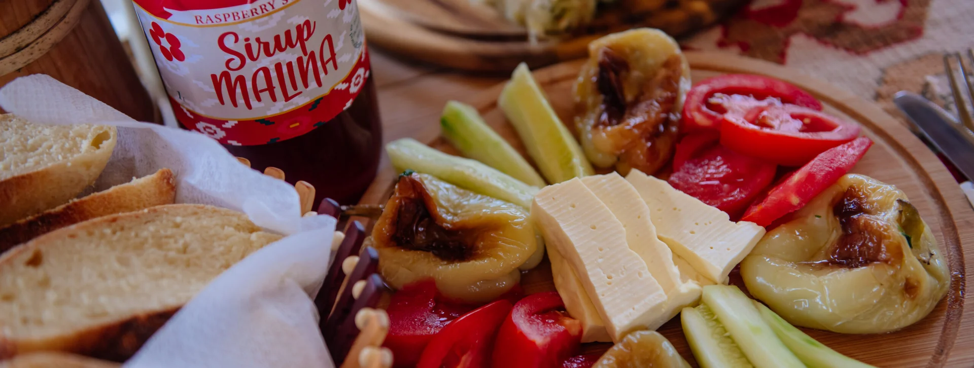 Sample local products at a typical table in Montenegro with bread, fruit, vegetables, and marmalade.