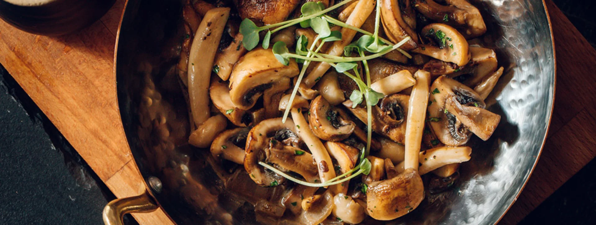 Pan of sautéed mushrooms with herbs, part of traditional Serbian cuisine.