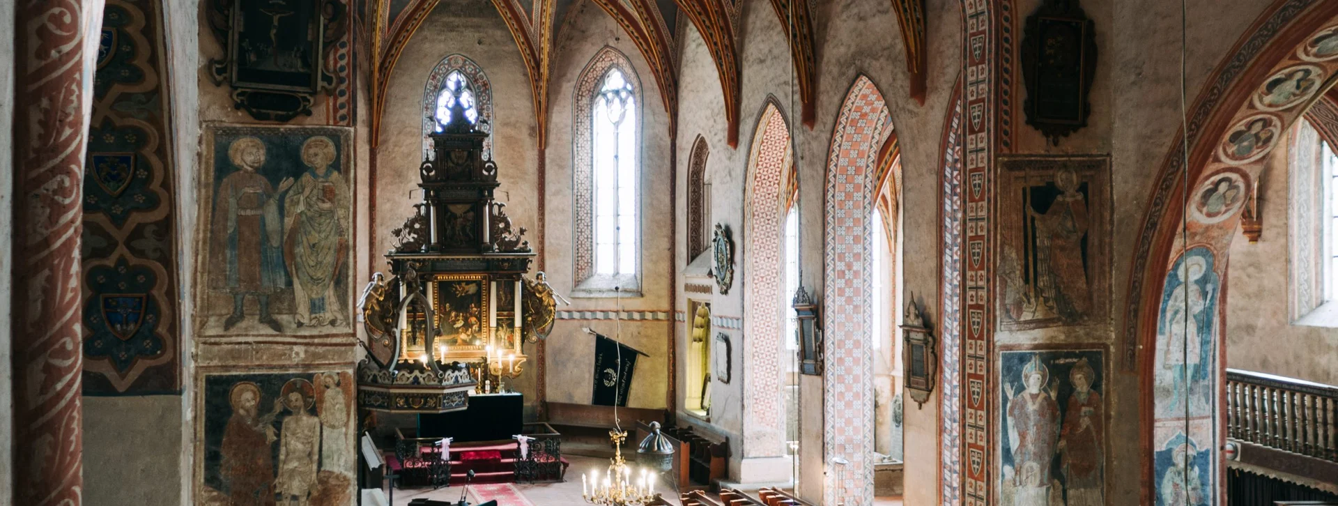 Interior view of Stiknik Church in Slovakia showcasing its Gothic architecture, arched windows, and medieval wall paintings that once served as a “Bible of the poor” for rural communities.