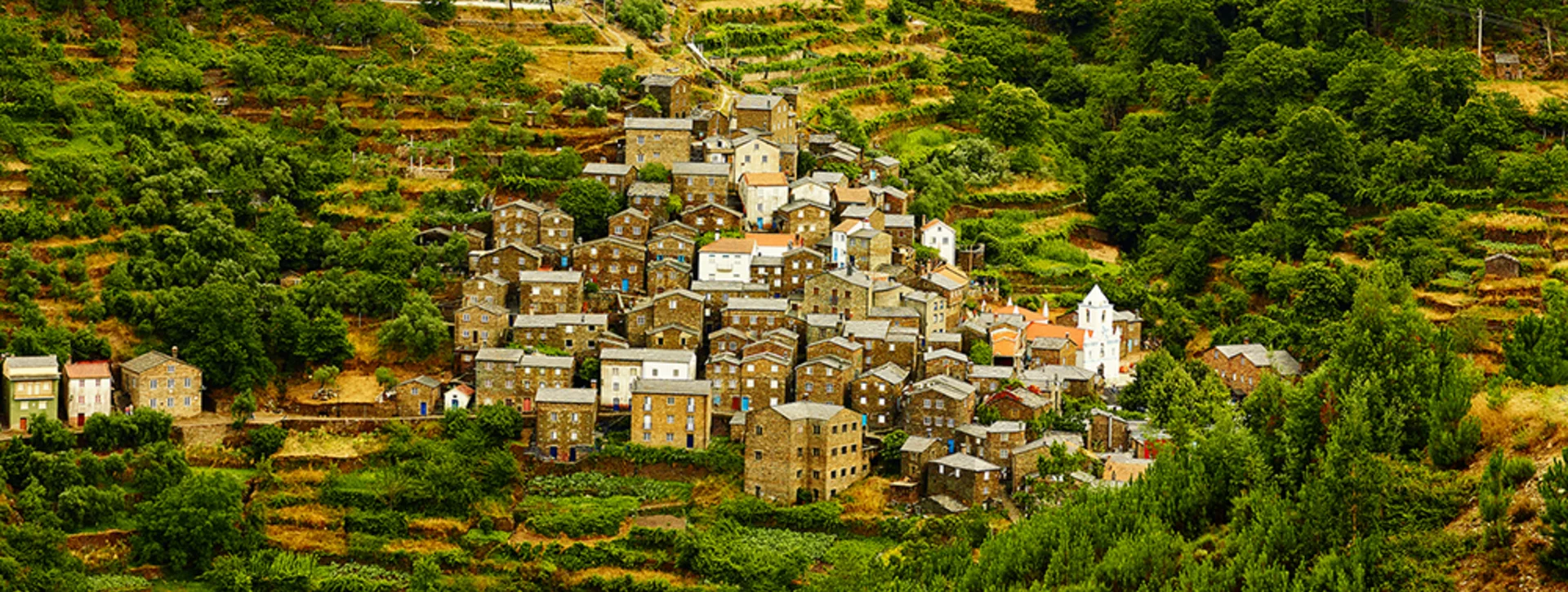 Stone houses of Piódão village nestled in green mountain terraces in Portugal