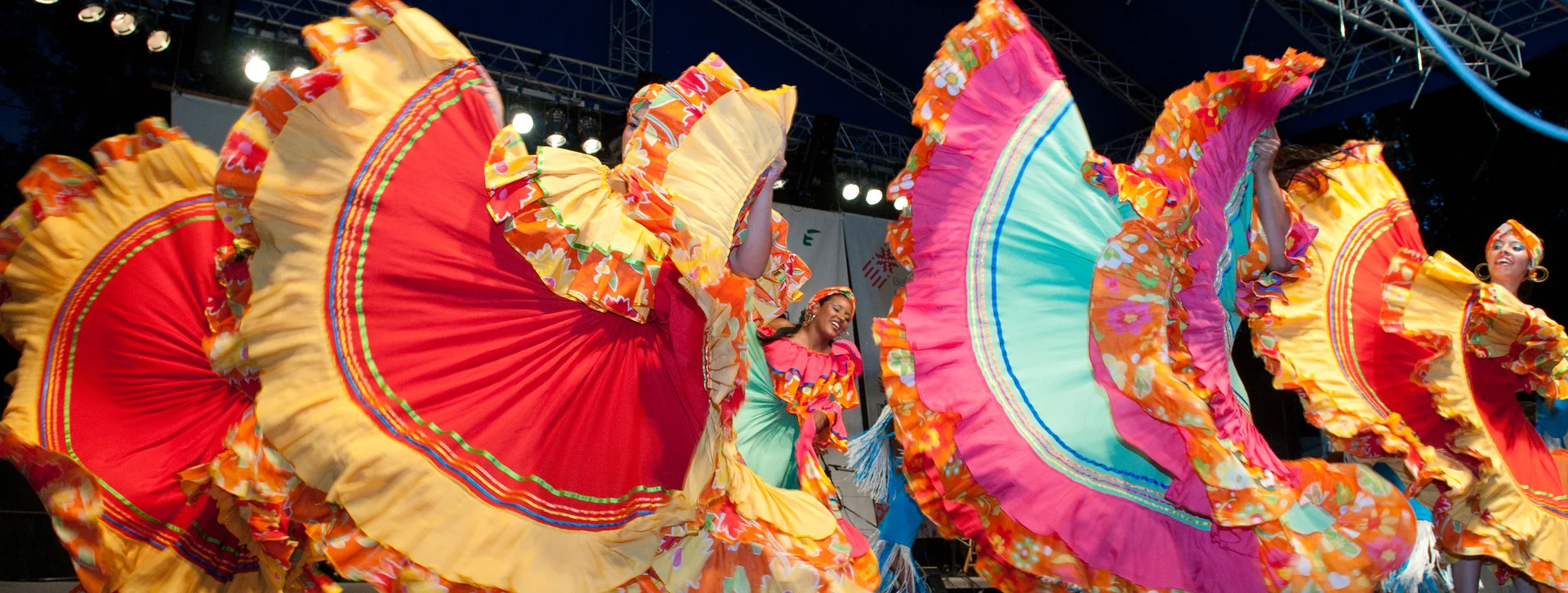 Dancers in colorful traditional dresses performing on stage.