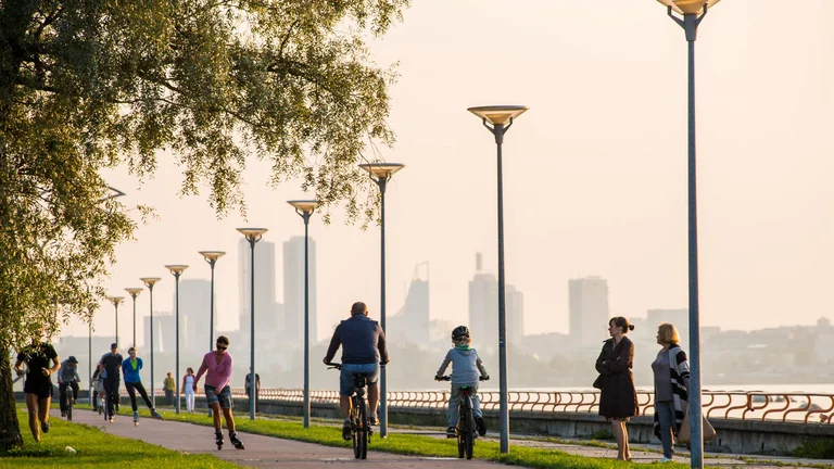 People enjoying riding the bikes and rollers on Bike Path Pirita Road next to the river in Estonia.