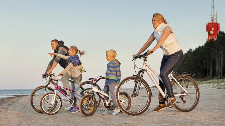 A family of 4 members on the beech enjoying the view from the bikes.