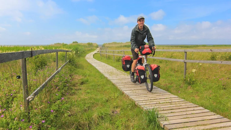 A man riding a bike in the middle of the meadow in Latvia.