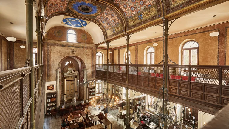 In the café, you will fall in love with the rich decorations and the inviting interior, filled with bookshelves, art, and the aroma of first-class coffee