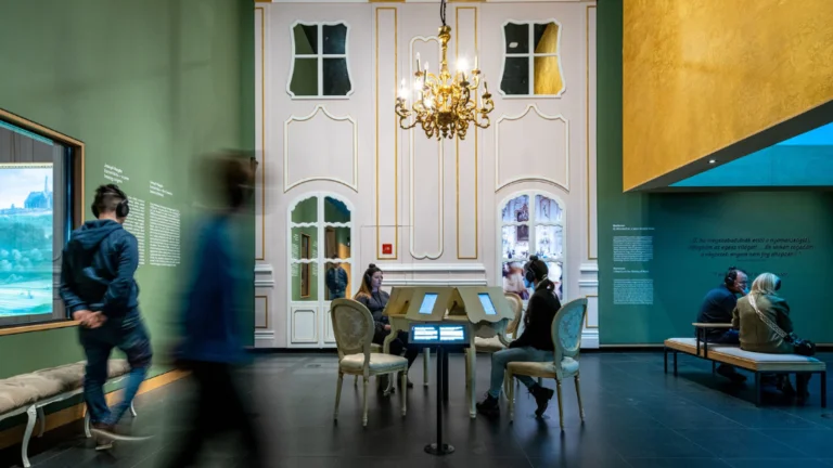 Visitors engage with interactive displays at a museum gallery with elegant decor.