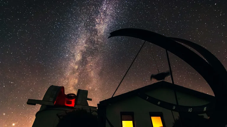 A starry sky featuring the Milky Way above the Kolonica Observatory, a stargazing destination in Slovakia.