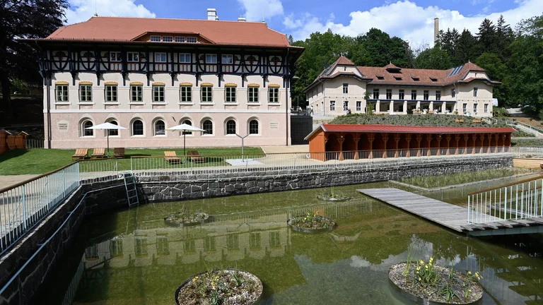Historic hydrotherapy building with sun loungers and a pond in Luhačovice.