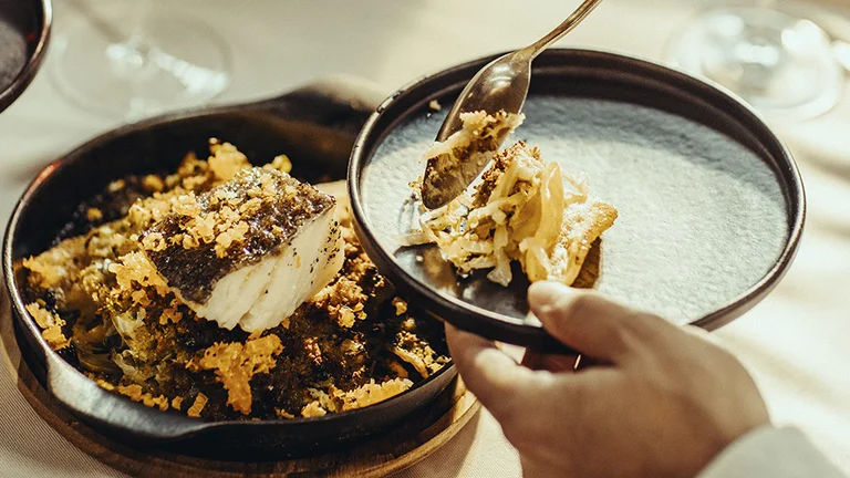 Portuguese bacalhau à brás codfish dish served with shredded potatoes, onions and olives.