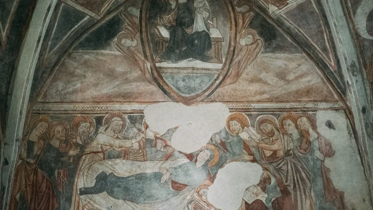Close-up of a medieval fresco inside the Gothic church of Rimavské Brezovo, Slovakia, depicting a sacred scene with the apostles painted on the historic interior wall.