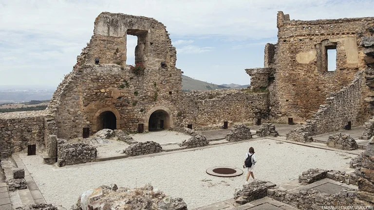 Visitor walking through the stone ruins of Castelo Rodrigo historic village in Portugal