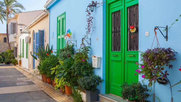 Colourful old town street with blue house, bright green door and potted plants
