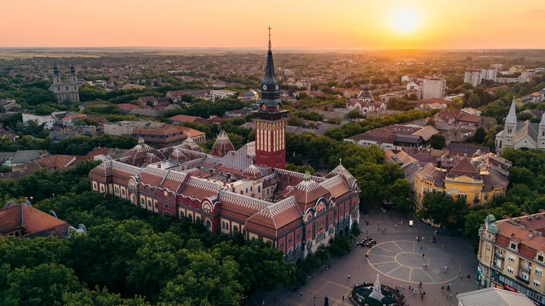 Aerial view of a city square with historic building at sunset.
