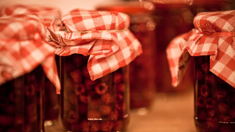 Jars of preserves with red and white checkered cloth lids